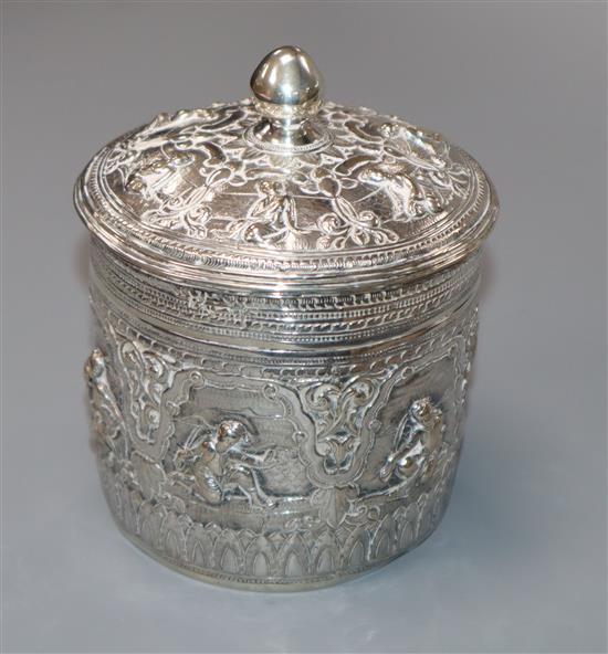 An Indian embossed white metal lidded jar, 10cm.